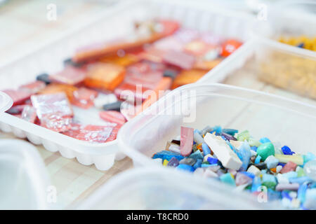 Containers with colored glass elements for mosaic - orange, red, pink, blue, for creativity art Stock Photo