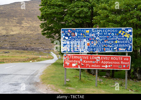 Warning signs covered in drivers' stickers at base of the Bealach na Ba pass on Applecross Peninsula on North Coast 500 scenic driving route in Scotla