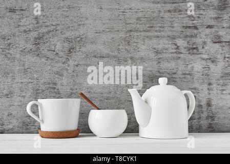 Cup of tea, teapot and sugar bowl on gray background Stock Photo