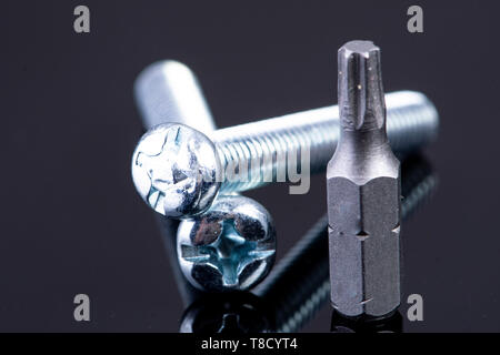 two screws with screws bit on black background Stock Photo