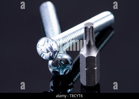 two screws with screws bit on black background Stock Photo