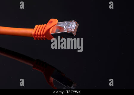 orange data cable for fast internet on black background for a modern home installation Stock Photo