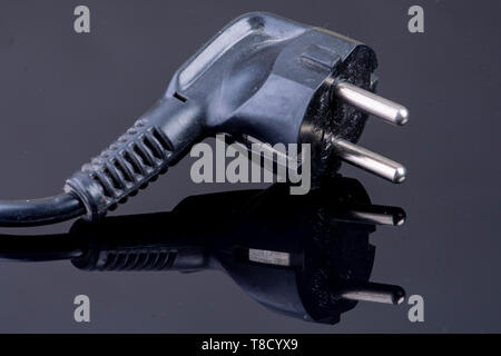 Power plug on reflective black surface Stock Photo