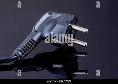 Power plug on reflective black surface Stock Photo