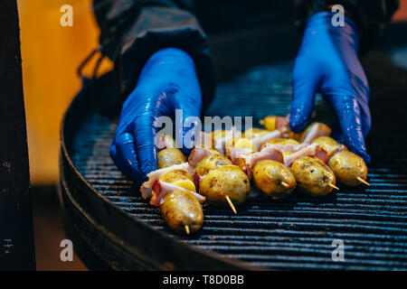 Potato with bacon on skewers cooked at the stake Stock Photo