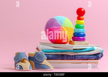 Donation concept. Kid toys, books and clothes fot donate or charity on pink background Stock Photo