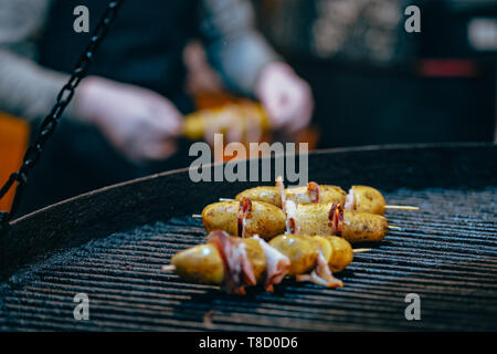 Potato with bacon on skewers cooked at the stake Stock Photo