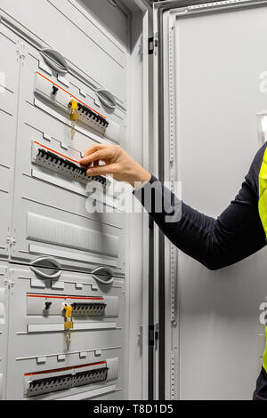 Male Electrician Checking Electric Fuse Board In Server Room Stock Photo