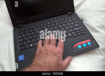 Close up of a man's left hand on a laptop computer keyboard Stock Photo