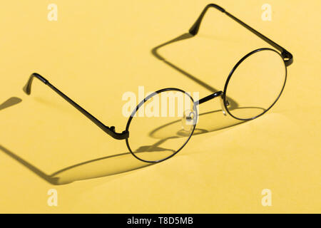 round eye glasses isolated on yellow background. close up photo. business concept. optics, health care, eyes care, fashion, style concepts Stock Photo