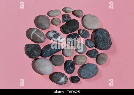 making picture with stones . top view photo. isolated pink background. Stock Photo