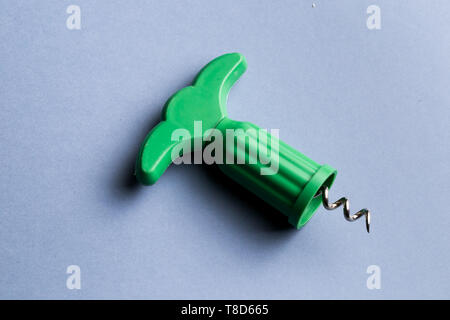 modern green corkscrew isolated on blue background, top view photo. close up shot Stock Photo