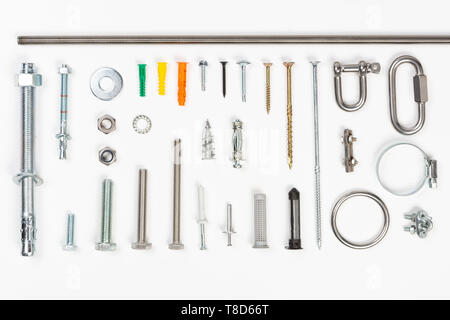 Top view of assorted materials carpenters use  like screws, bolts, fixings, nuts screws and nails on a white background. Stock Photo