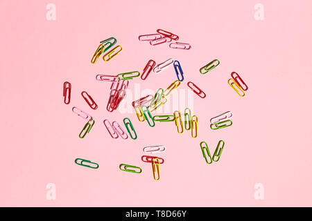 pile of paper clips isolated on pink background, paperwork, office goods concept, messy office table Stock Photo