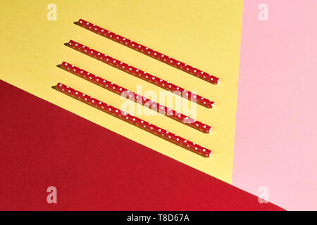 four plastic ecological vintage straws isolated on the yellow, pink, red background , top view photo Stock Photo
