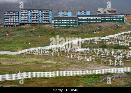 Greenland, central western region, Sisimiut (formerly Holsteinsborg), the cemetery, the coffins are placed on the surface and then covered with stones or cement, the ground can not be dug, the tombs are then decorated with artificial flowers, social housing in the background Stock Photo