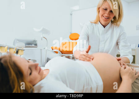 Pregnant woman at a checkup with her female doctor at clinic Stock Photo