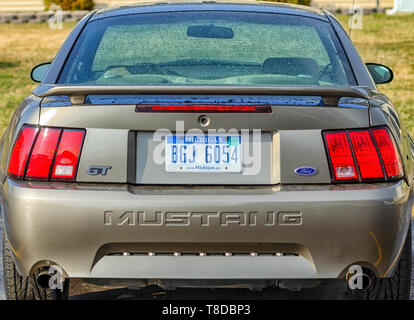A rear profile/rear bumper of a 2001 Ford Mustang GT Coupe. Tiny drops of water cover the body of the sports car after a summer storm. Stock Photo