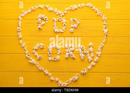 Heart and words made of delicious popcorn on wooden background Stock Photo
