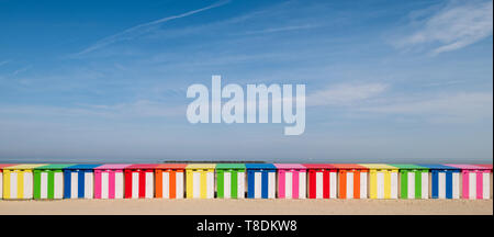 Dunkerque, France: Row of brightly coloured striped beach cabins on the sea front at Malo-Les-Bains beach in Dunkirk. Stock Photo