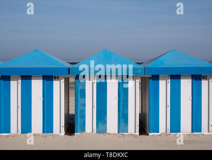 Blue and white striped beach huts on the sand on the sea front at Malo-Les-Bains beach in Dunkirk, France Stock Photo