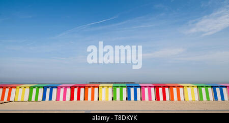 Dunkerque, France: Row of brightly coloured striped beach cabins on the sea front at Malo-Les-Bains beach in Dunkirk. Stock Photo