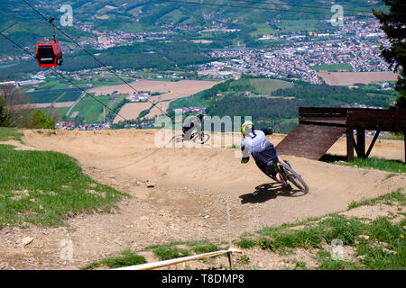 Maribor, Slovenia - May 2, 2019: Downhill mountain bikers riding down the trail on Pohorje near Maribor, Slovenia. Pohorje bike park is very popular Stock Photo