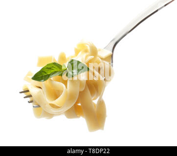 Delicious pasta with basil on fork against white background Stock Photo