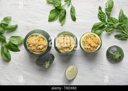 Quinoa stuffed zucchinis on white wooden table Stock Photo