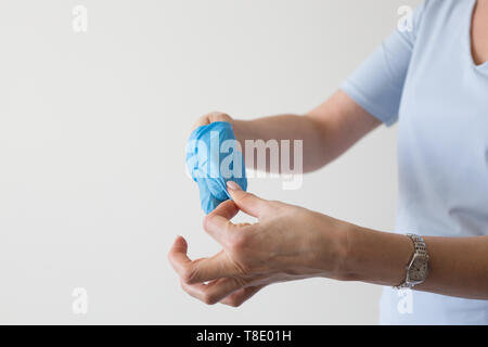 Female hand blue recycling used medical glove  closeup Stock Photo