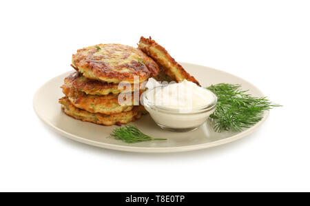 Plate with zucchini pancakes and sauce isolated on white Stock Photo