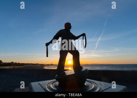 Newlyn, Cornwall, UK. 13th May 2019. A fresh breeze and another glorious sunrise with Tom Leapers memorial to Newlyn Fisherman statue silhouetted by the rising Sun. Credit Simon Maycock / Alamy Live News. Stock Photo