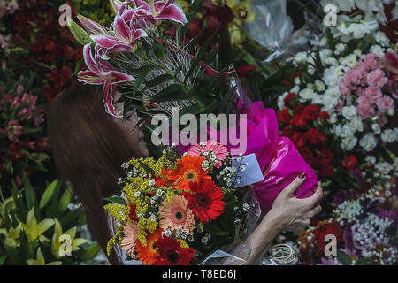 Sao Paulo, Brazil. 12th May, 2019. A woman is seen holding flowers at a flower market on Mother's Day in Sao Paulo, Brazil, May 12, 2019. Credit: Rahel Patrasso/Xinhua/Alamy Live News Stock Photo