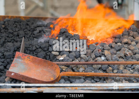 Farrier's furnace with flaming coals and forging tools Stock Photo