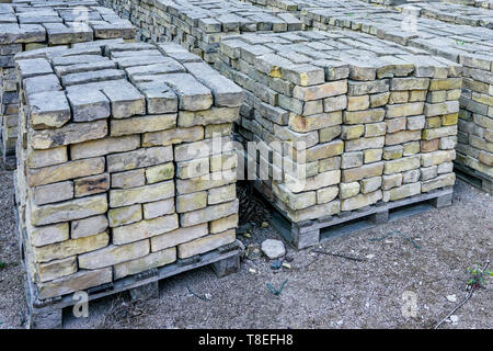old used bricks, stacked into cubes on pallets Stock Photo