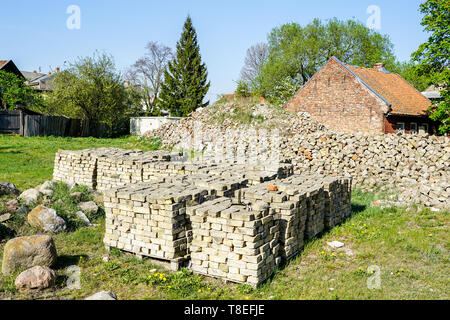 old used bricks, stacked into cubes on pallets Stock Photo