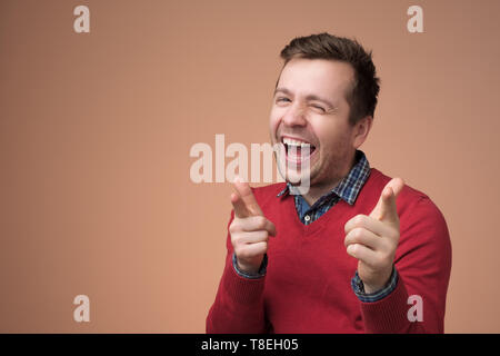 European young man in red sweater laughing on funny joke Stock Photo