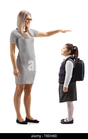 Full length shot of a woman gesturing with hand and showing the height of a little schoolgirl isolated on white background Stock Photo
