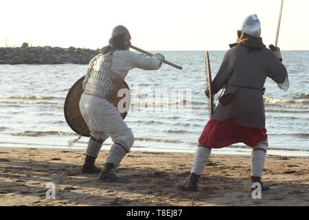 Two medieval Slav warriors are fighting with swords and shields on the beach Stock Photo