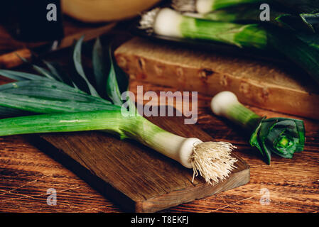 Fresh green leek on wooden cutting board Stock Photo