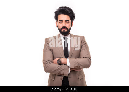 Young man wearing a suit standing crossed arms smiling, isolated on a white background. Stock Photo