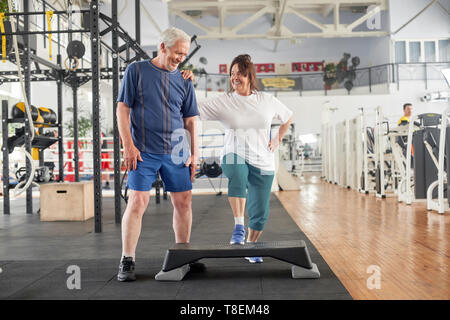 Joyful elederly couple at modern gym. Happy active seniors at fitness club. Enjoy your life. Stock Photo