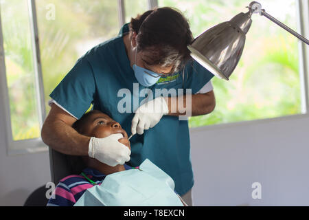 Sosúa, Puerto Plata Province, Dominican Republic - May 11, 2013: Volunteer dentist working on child in Dominican Republic at Monkey Jungle medical facility. Stock Photo