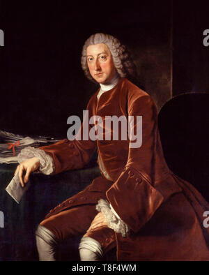 Portrait of the British statesman William Pitt, 1st Earl of Chatham (1708-1778), at three-quarter length, grey wig falling behind shoulders; rich brown velvet suit, white cravat, shirt and wrist ruffles; on the table an inkstand, pen and papers, a letter in his right hand; brown interior background; lit from left Stock Photo