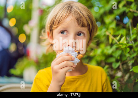 Sweet little caucasian boy, eating pancakes and drinking orange juice Stock Photo