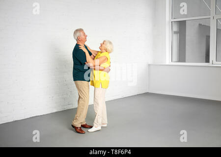 Happy mature couple dancing in their new house Stock Photo