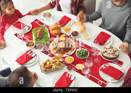 Family praying before having Christmas dinner at home Stock Photo