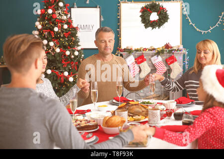 Happy family praying before having Christmas dinner at home Stock Photo