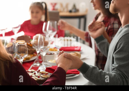 Family praying before having Christmas dinner at home Stock Photo