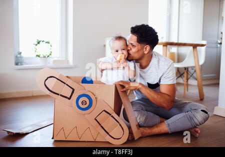 Father and small toddler son indoors at home, playing. Stock Photo